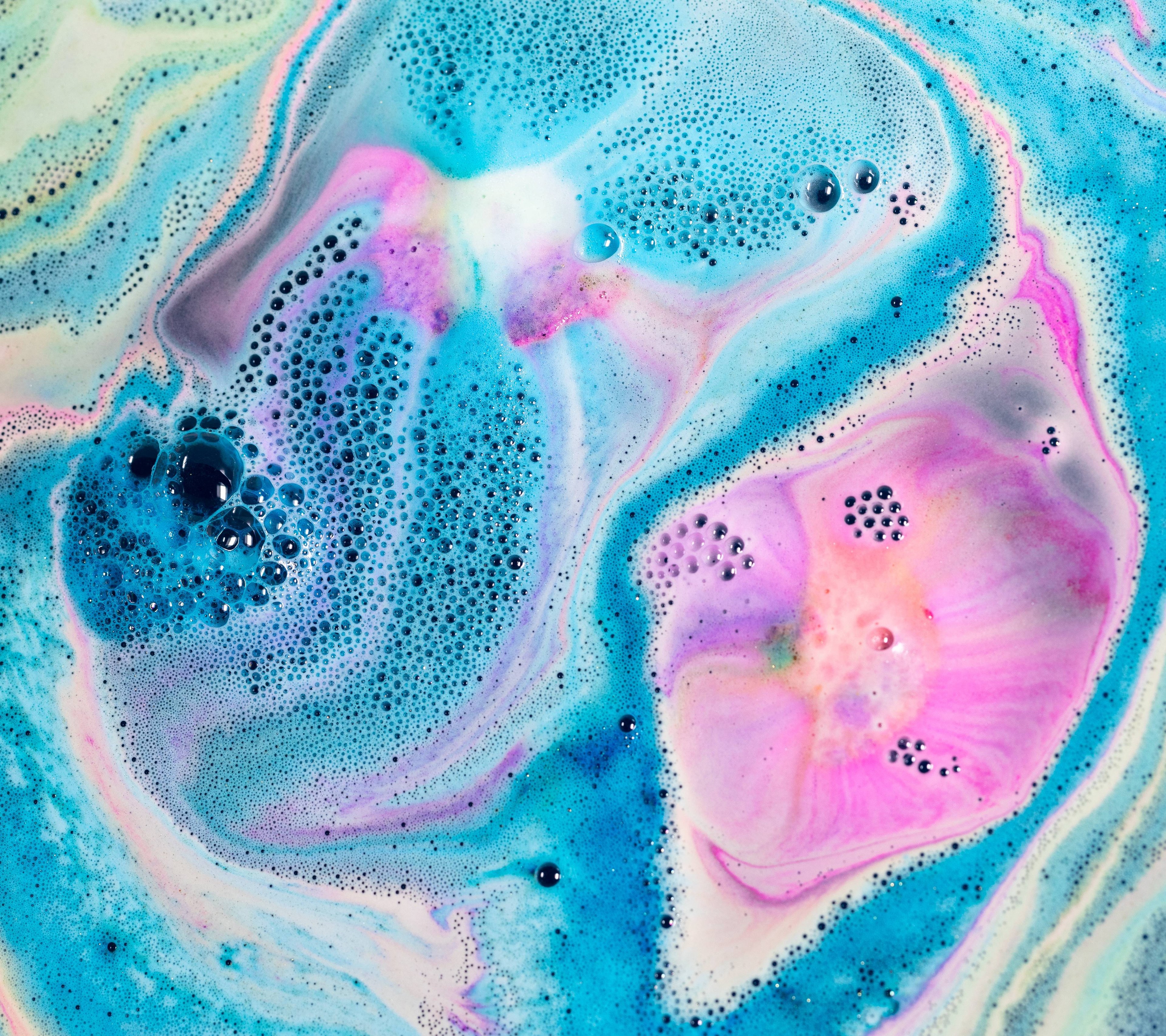 Bright blue, pink and white foam sit atop dark waters, creating a deep space effect. A myriad of bubbles complete this galaxy from the Intergalactic bath bomb.