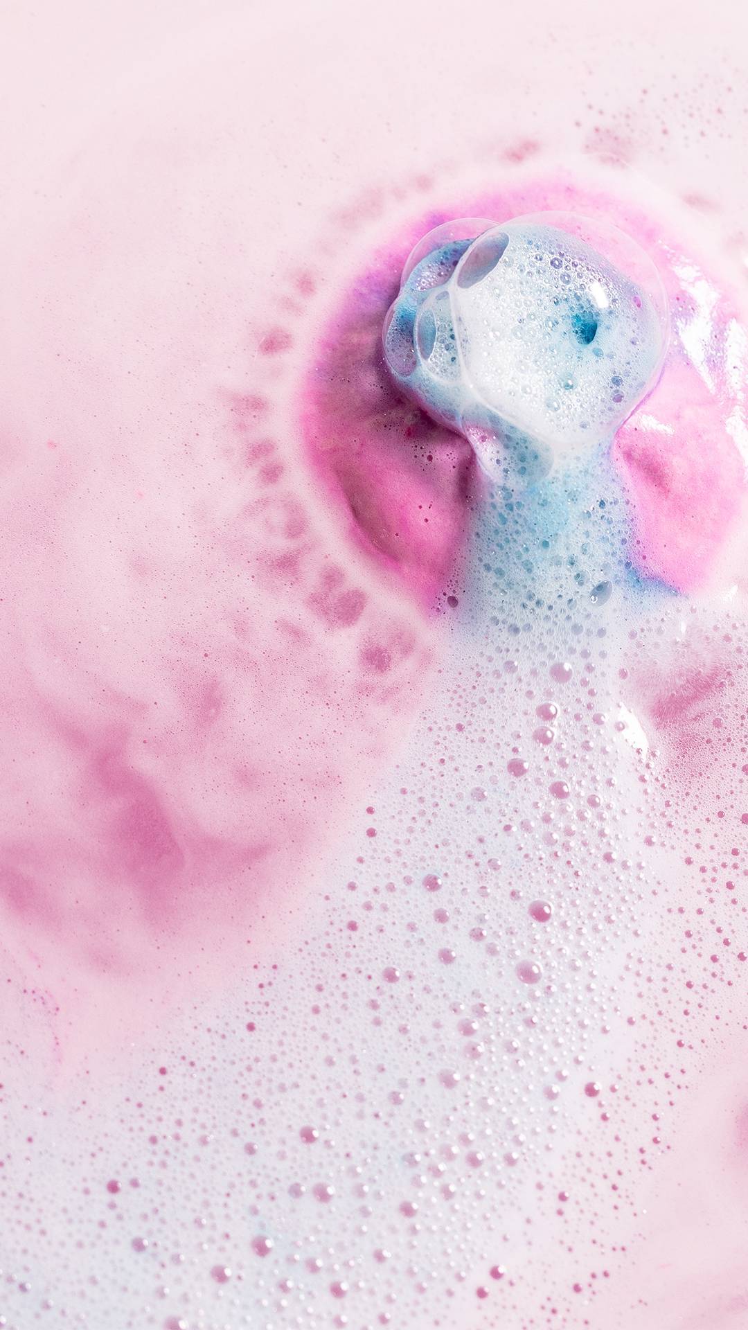 The Twilight bath bomb is slowly dissolving dispersing a thick blanket of delicate pink and purple velvety foam with a burst of blue in the centre. 